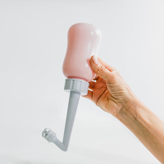 Hand holding Partum Panties peri bottle designed for postpartum recovery